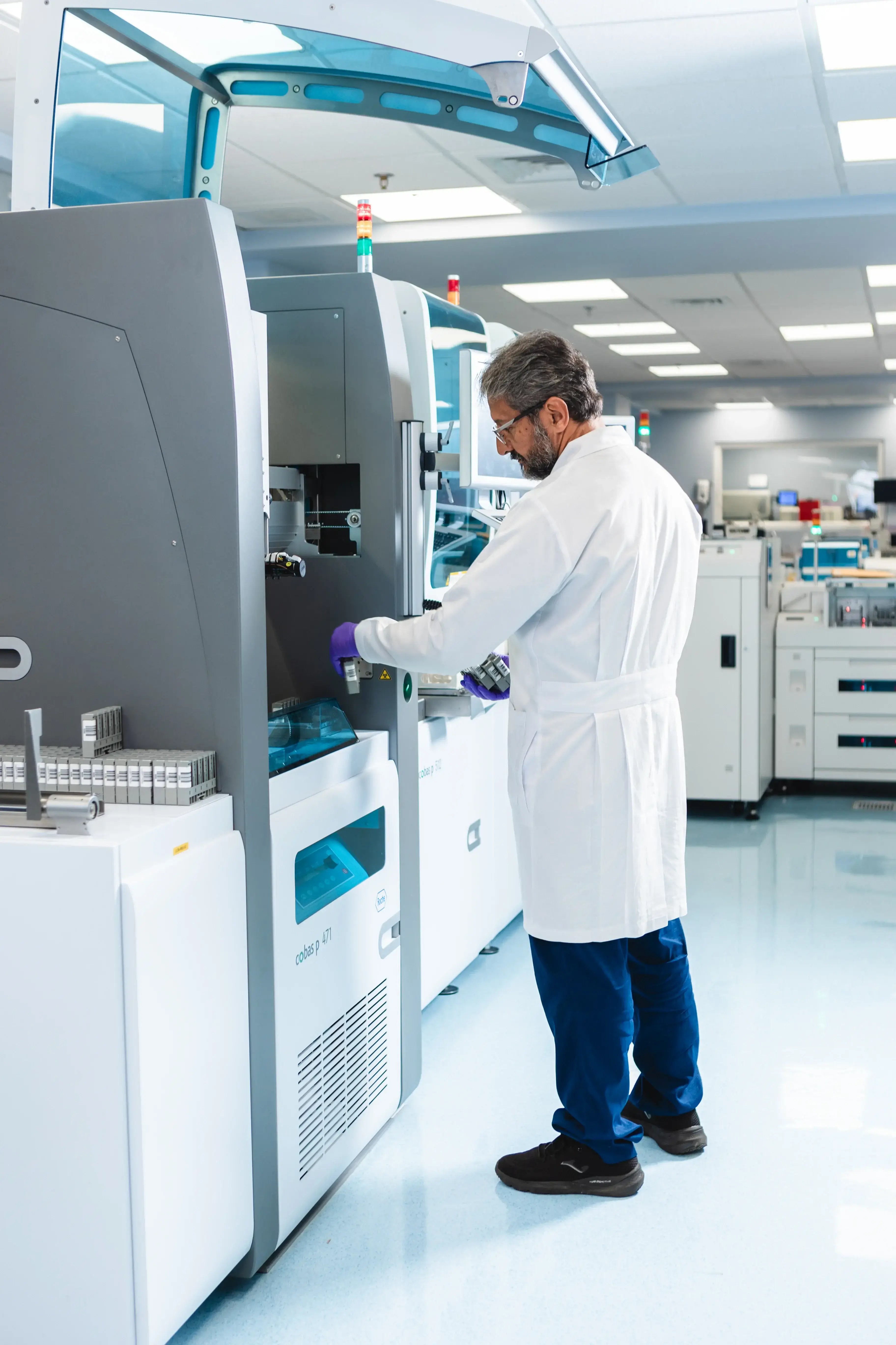 Técnico de laboratorio en Clínica Bíblica utilizando equipo automatizado para análisis clínicos avanzados