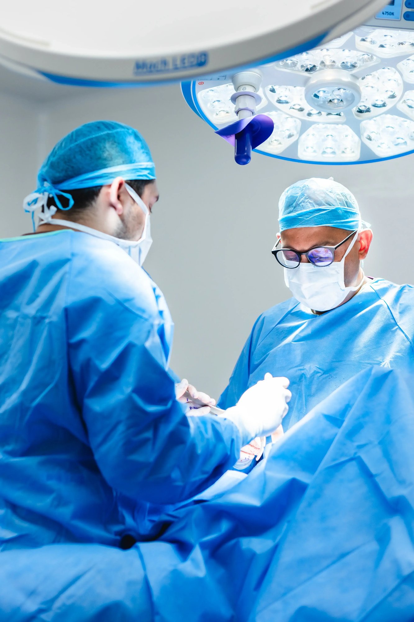 Cirujanos realizando operación en quirófano con equipo médico avanzado