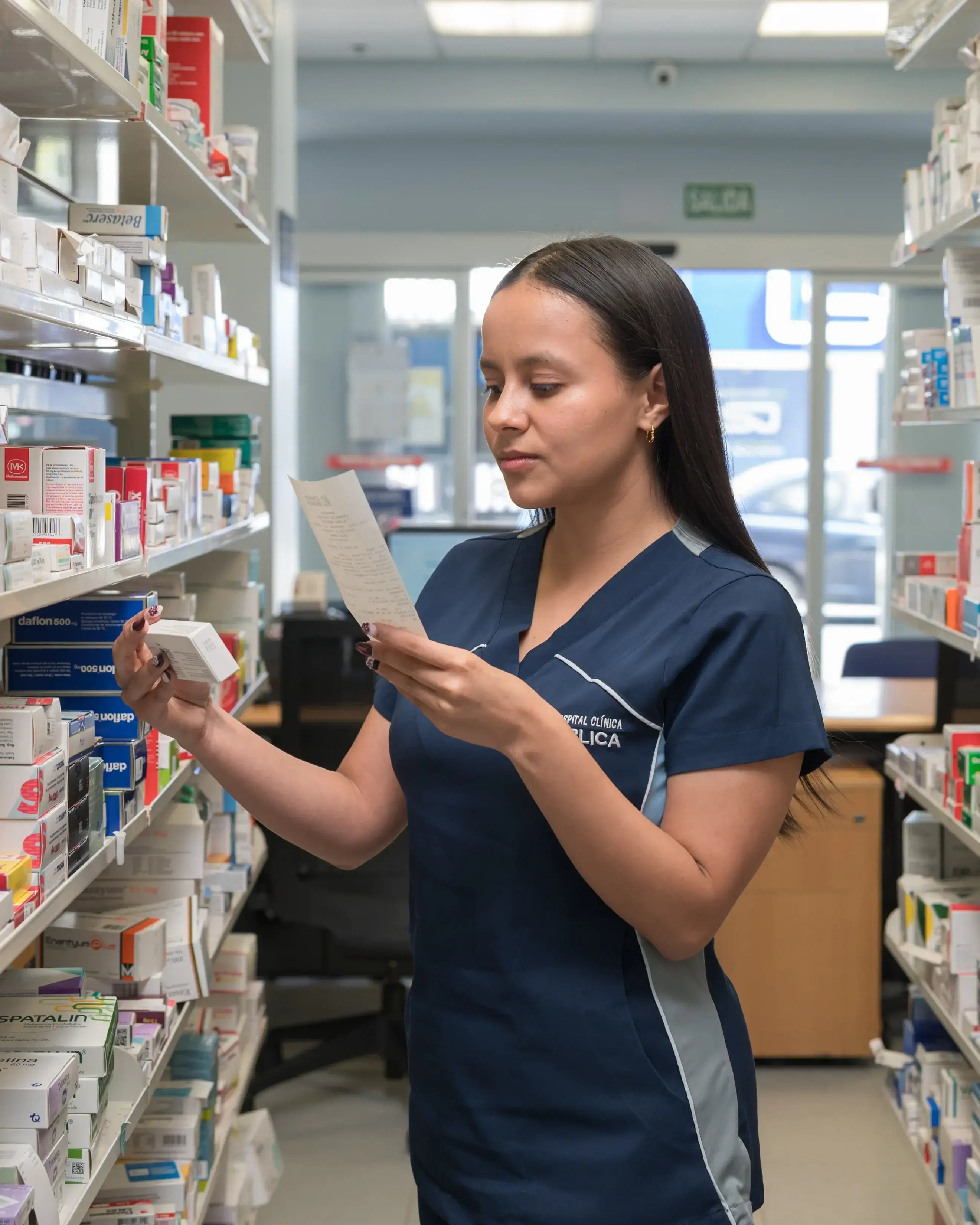 Farmacéutica de Clínica Bíblica revisando receta y medicamentos en la farmacia hospitalaria