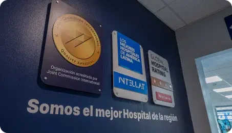 Pared institucional que exhibe las placas de acreditación de la Joint Commission International y sellos de calidad del Hospital Clínica Bíblica.
