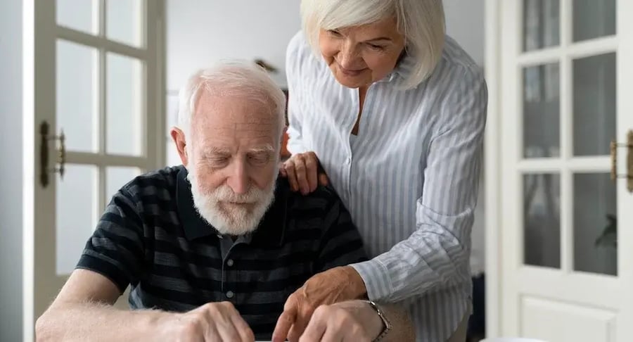 Elderly woman accompanying an elderly man at home with a caring attitude