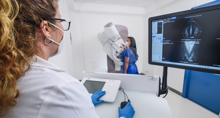 Una paciente de espaldas recibiendo un examen de detección temprana en un moderno mamógrafo digital MAMMOMAT Fusion en la sede de Santa Ana.