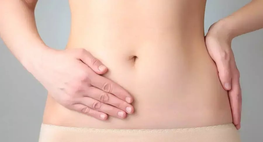 Woman with abdominal pain holding the side of her lower belly