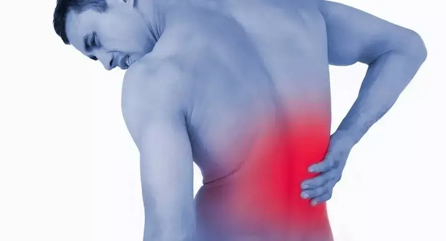 Man with low back pain in the lower back highlighted in red