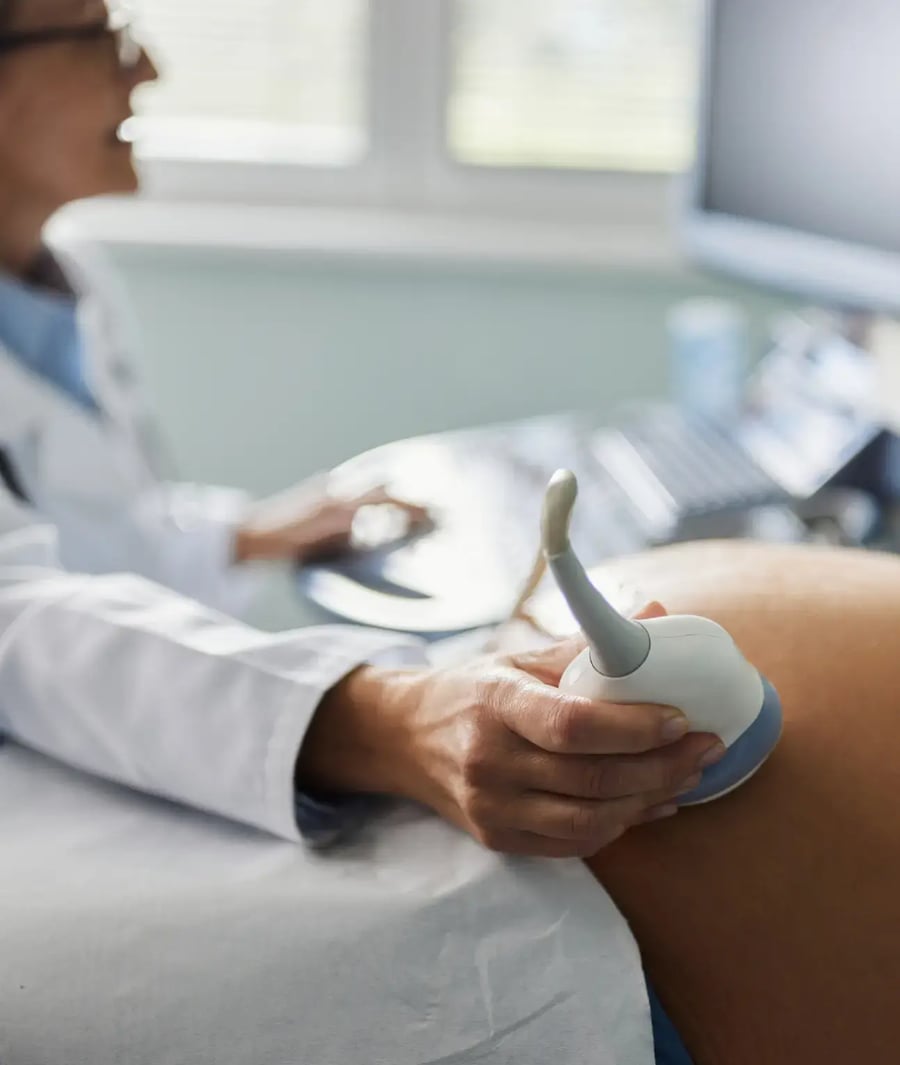 Doctor performing prenatal ultrasound on a pregnant woman at the Clínica Bíblica.