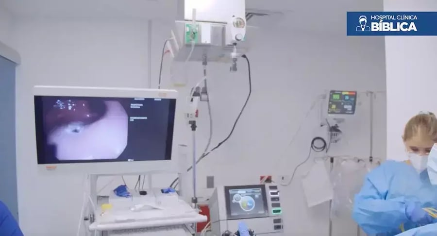 Physician performing endoscopic procedure with on-screen monitoring in specialized room