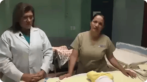 Personal de salud enseñando cuidados de recién nacidos en sala neonatal.