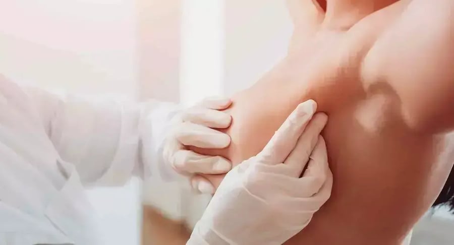 Doctor performing clinical breast exam on female patient
