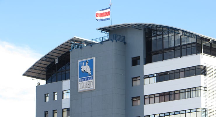 Fachada del Hospital Clínica Bíblica con la bandera de Costa Rica en la parte superior