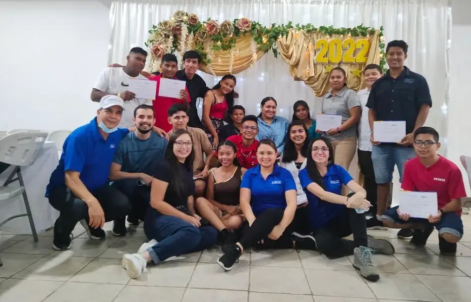 Equipo de trabajo posando juntos frente a una decoración con números 2022.