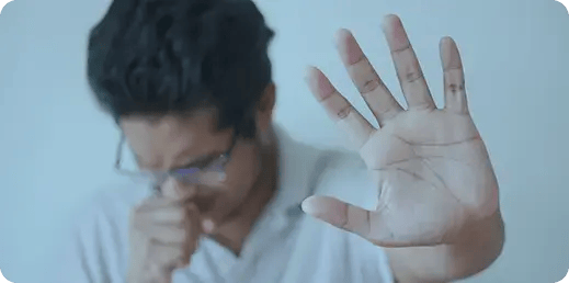 Hombre con tos cubriéndose y levantando la mano en señal de prevención