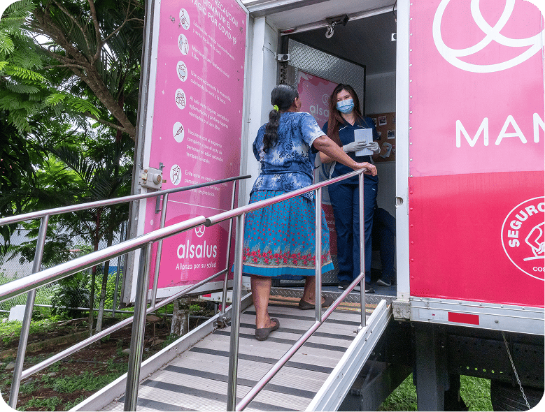 Unidad móvil de salud con rampa de acceso y paciente ingresando.