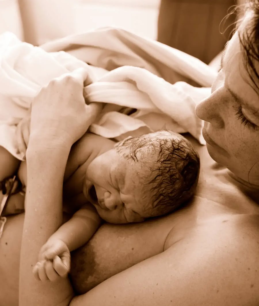 Mother cuddling her newborn after delivery at Clínica Bíblica.