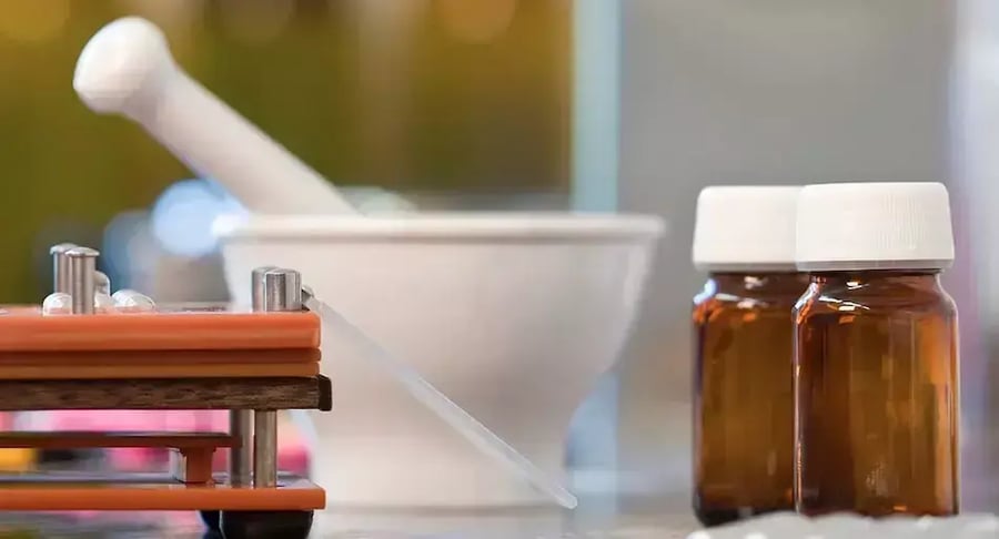 Medicine bottles next to a mortar in a compounding laboratory