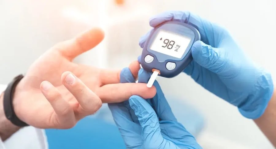 Health professional measuring blood glucose level with glucometer