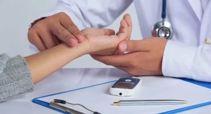 Physician checking patient's pulse with glucometer on the table in prediabetes screening