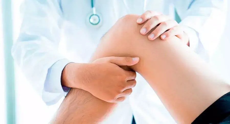 Physician examining a patient's knee during orthopedic check-up