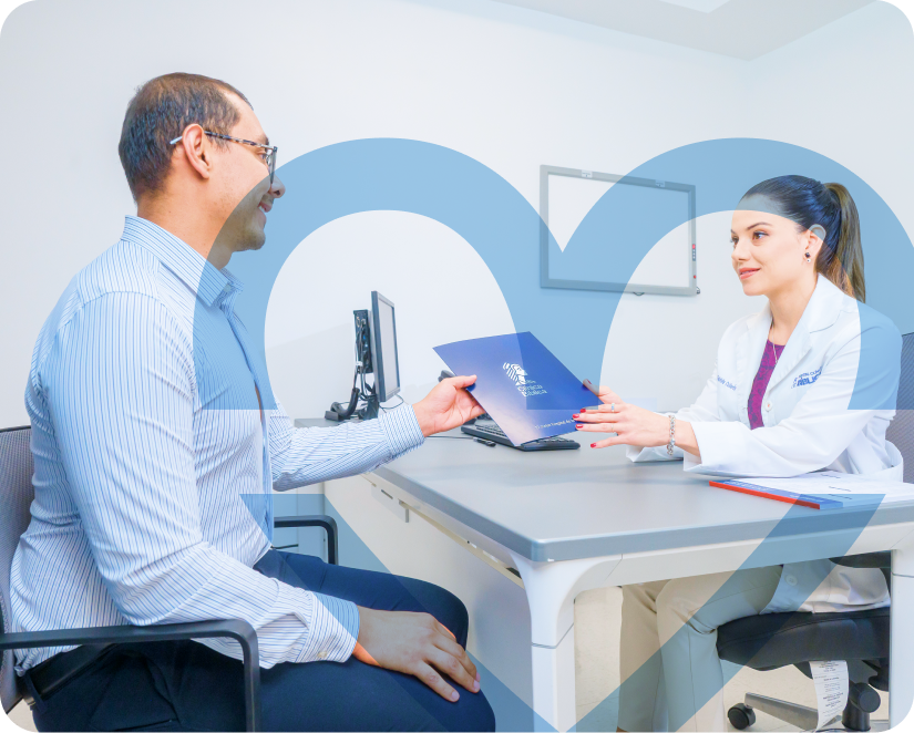 Médica entregando una carpeta azul a un paciente durante una consulta en una oficina clínica.