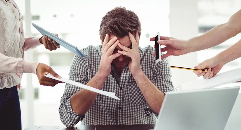 Stressed man in the office with overwork and multiple responsibilities